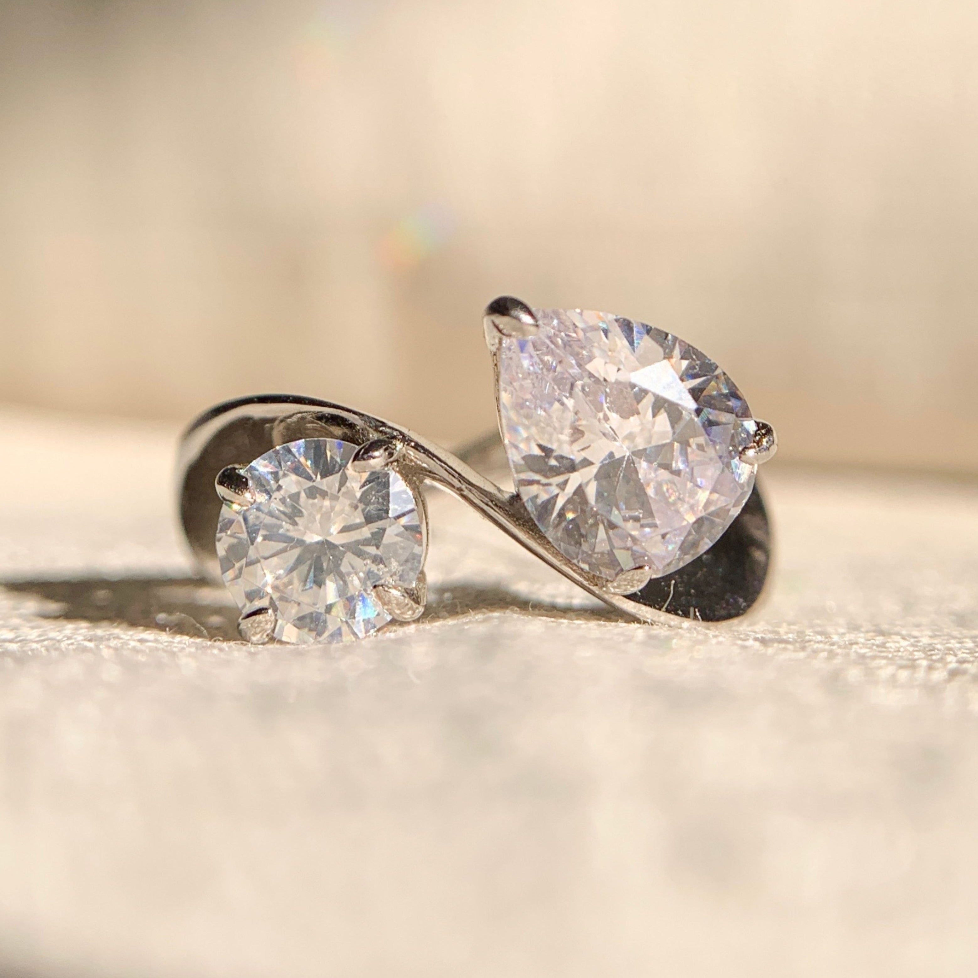 Toi et Moi engagement ring with round and pear diamonds in a luxurious setting